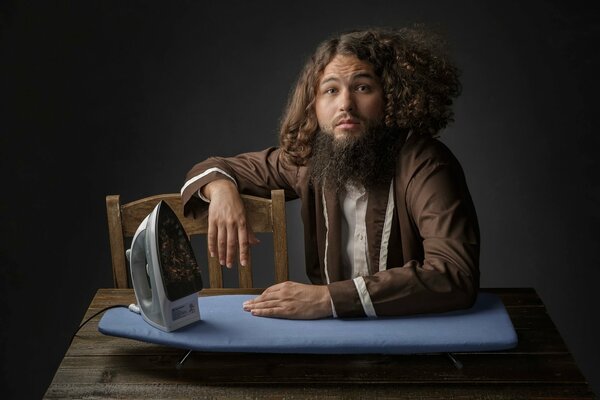 Curly-haired man with an ironing board and iron