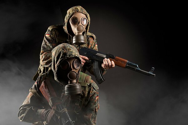 Żołnierze w maskach gazowych z karabinami w ręku. Wokół dym