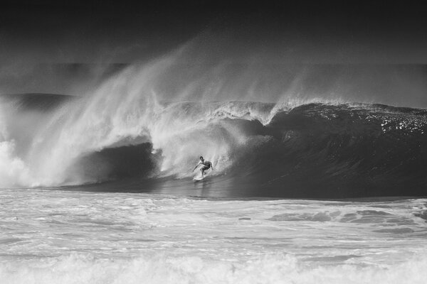 Black and white image of a surfer in a big wave