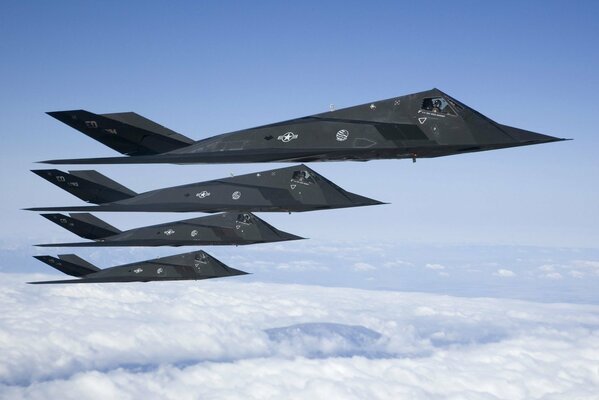 A group of fighter jets flying above the clouds