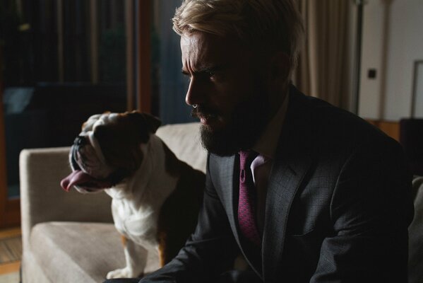Hombre con barba en castium en el Sofá con un perro