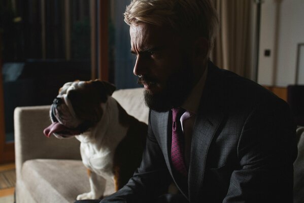 Uomo con la barba in castyum sul divano con il cane