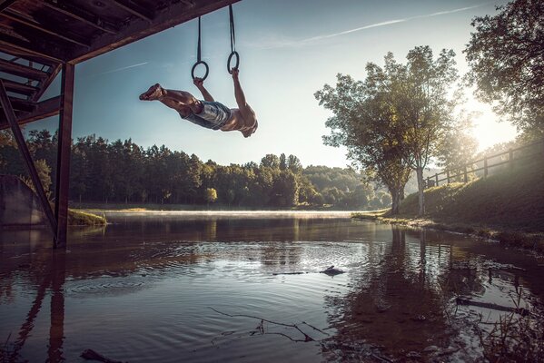 Sportlerübungen an den Ringen auf der Brücke