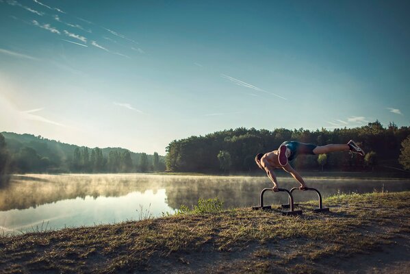 An athlete in the morning fog on the lake