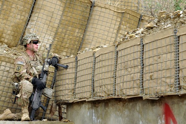 An armed soldier is sitting in ambush