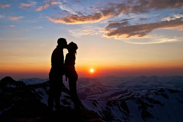 A kiss of a couple in love at sunset