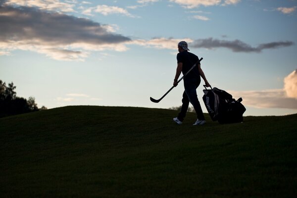 Auf hellem Himmelshintergrund ein Bild eines Sportlers mit einem Putter