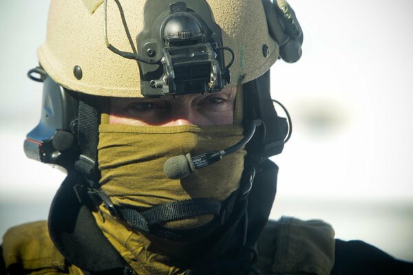 Soldat en tenue se tient avec un microphone et regarde