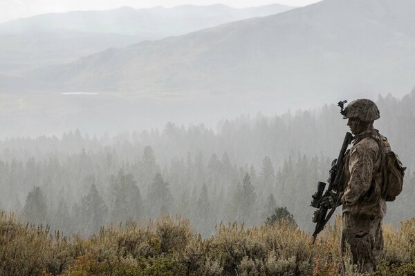 Soldado con armas en el fondo de los bosques