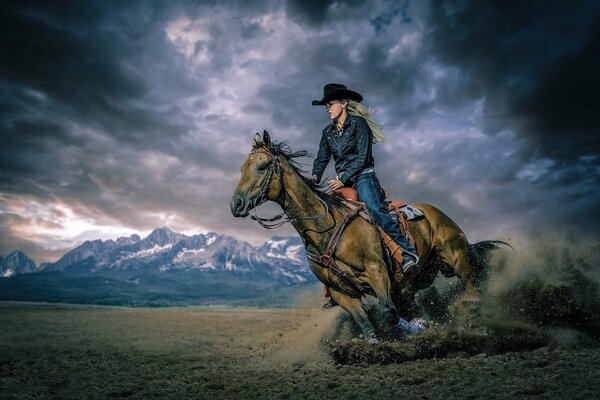 The girl is a horsewoman riding in the mountains