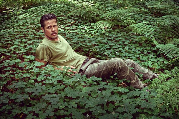L attore Brad Pitt giace tra l erba verde