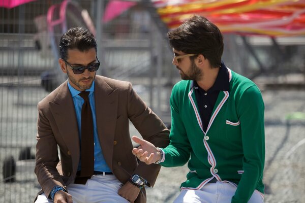 Two men on the street with glasses talking