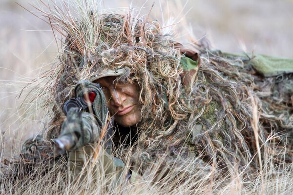 Le tireur d élite est déguisé en herbe et vise le fusil