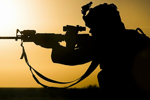 The silhouette of a sniper who takes aim