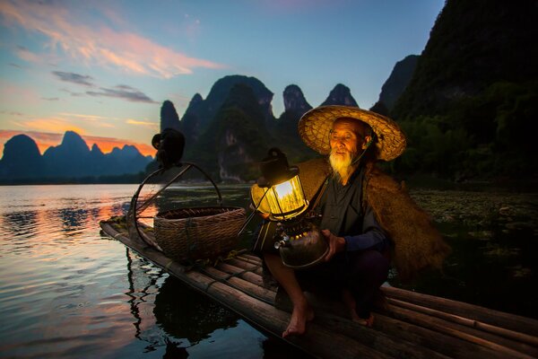 China Fischer auf einem Boot mit Laterne