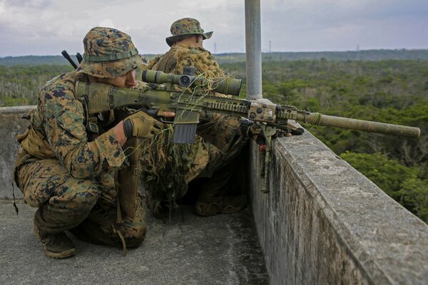 Francotiradores con rifles en el techo de la casa