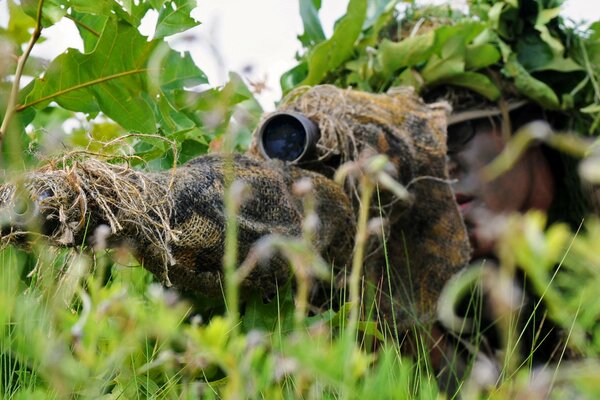 Sniper déguisé avec un fusil dans l herbe