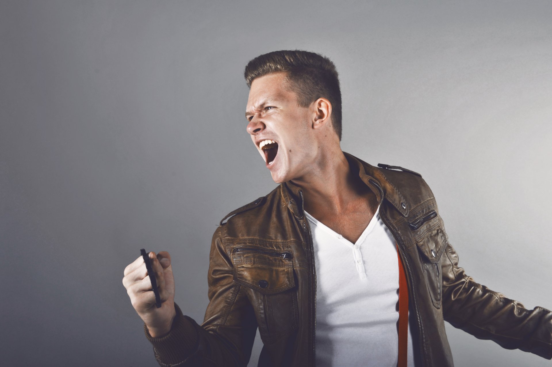 novio grito nudillos chaqueta de cuero dientes blancos camiseta blanca tirantes corte de pelo corto rabia enojo