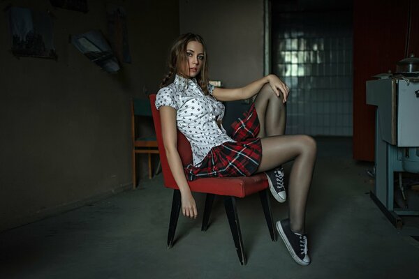 A girl in a school uniform and sneakers