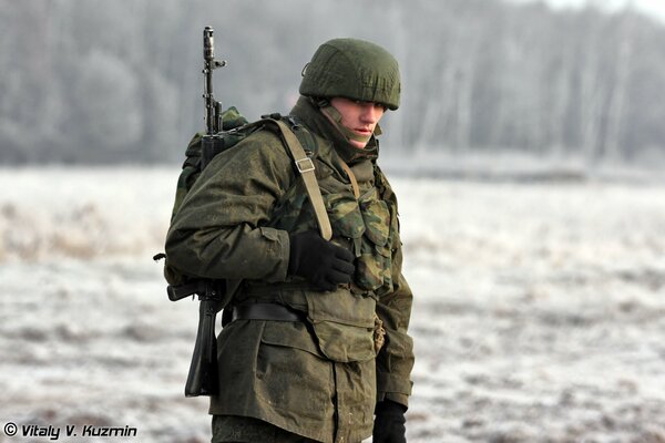 Ein Soldat mit einer Waffe schaut genau hin