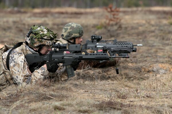 Two soldiers with guns aim at the target