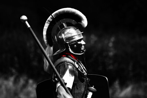 Gladiator stands in armor on a black background