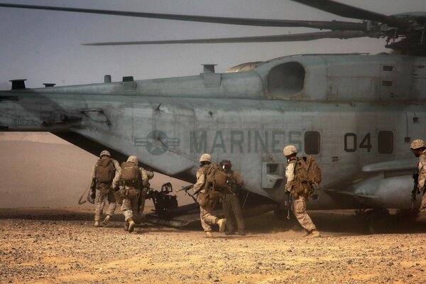 Soldats dans le désert près d un gros hélicoptère