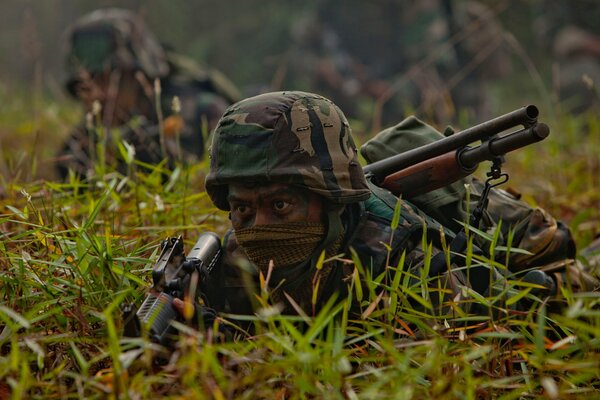 Soldiers with weapons disguised themselves in the grass