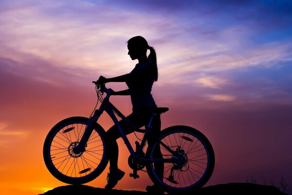 A girl at sunset. Cycling