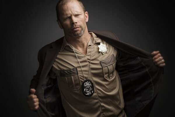 A man in a police uniform on a dark background