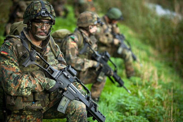 Deutsche Soldaten in sommerlicher Tarnung mit Waffen