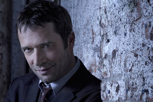 Portrait of James Purefoy by the wall