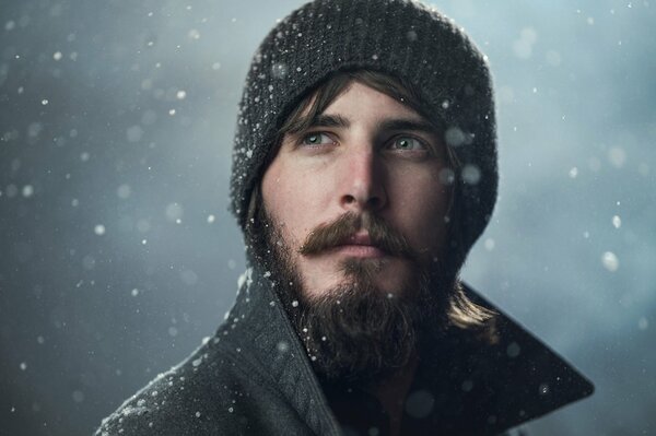 Retrato de un hombre sobre un fondo blanco y nevando