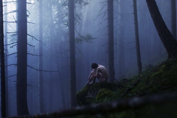 Nackter Mann im nebligen Wald