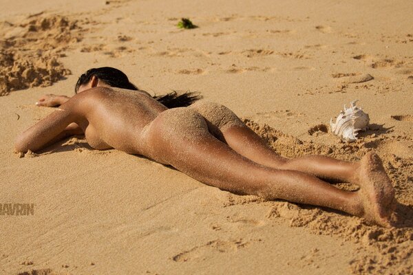 Bella ragazza prende il sole sulla spiaggia