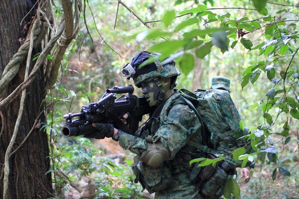 A Singaporean soldier shoots from a machine gun