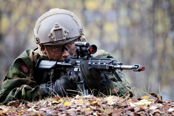 A male soldier aims at a machine gun