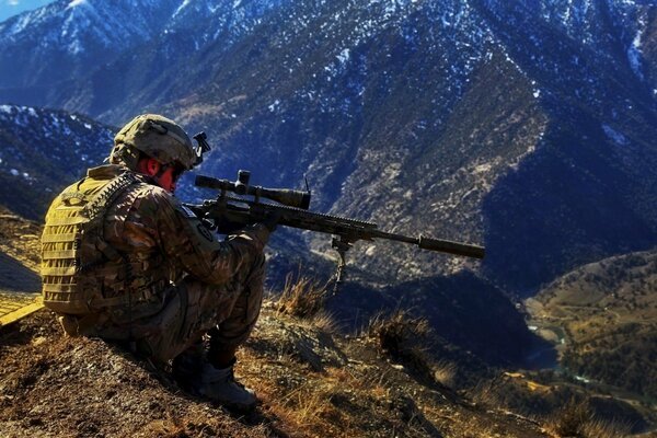 Sniper militaire assis dans les montagnes