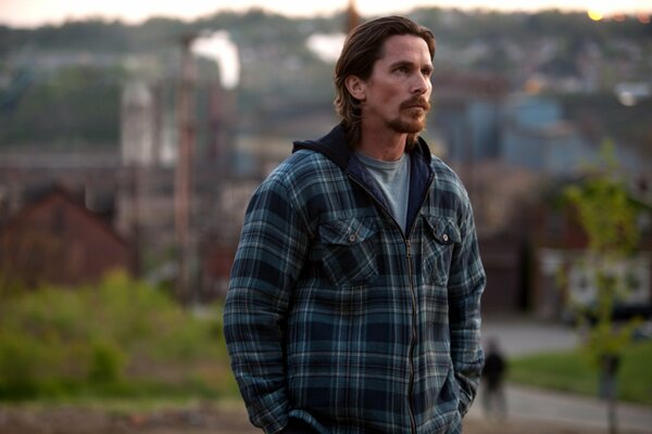 Portrait of Christian in a plaid jacket against the background of the village