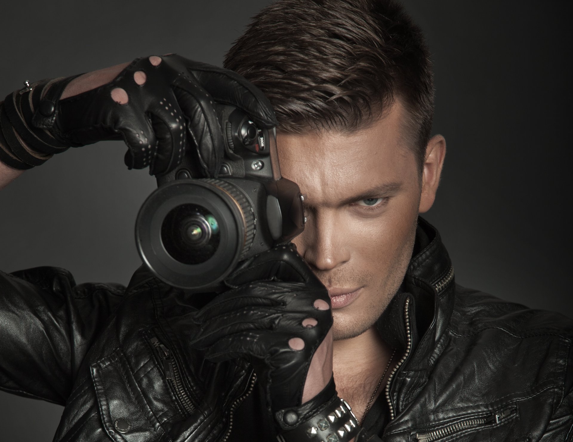 guy gray eyes brown hair jacket gloves a camera len