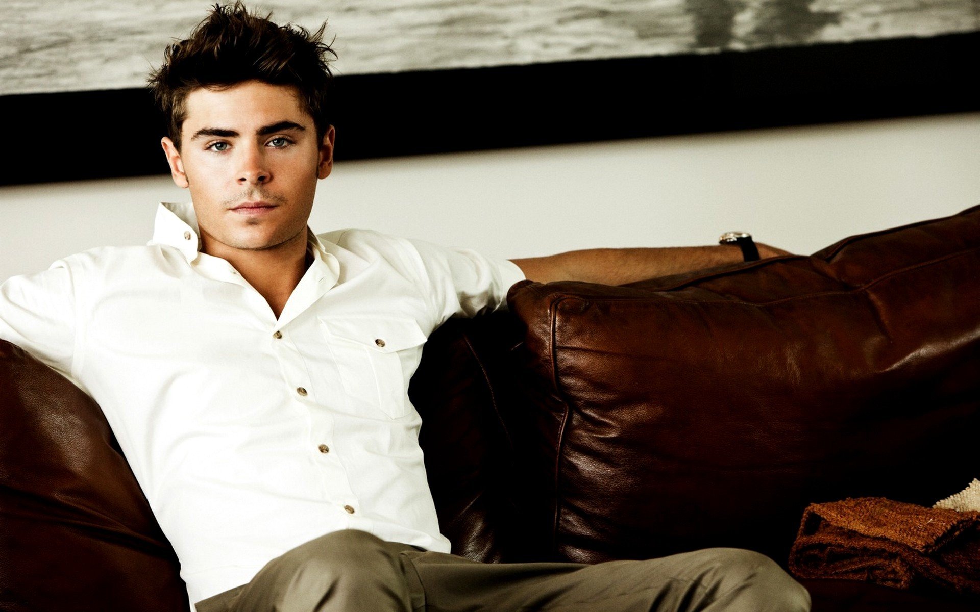 zac efron acteur garçon homme visage cheveux regard chemise pantalon canapé