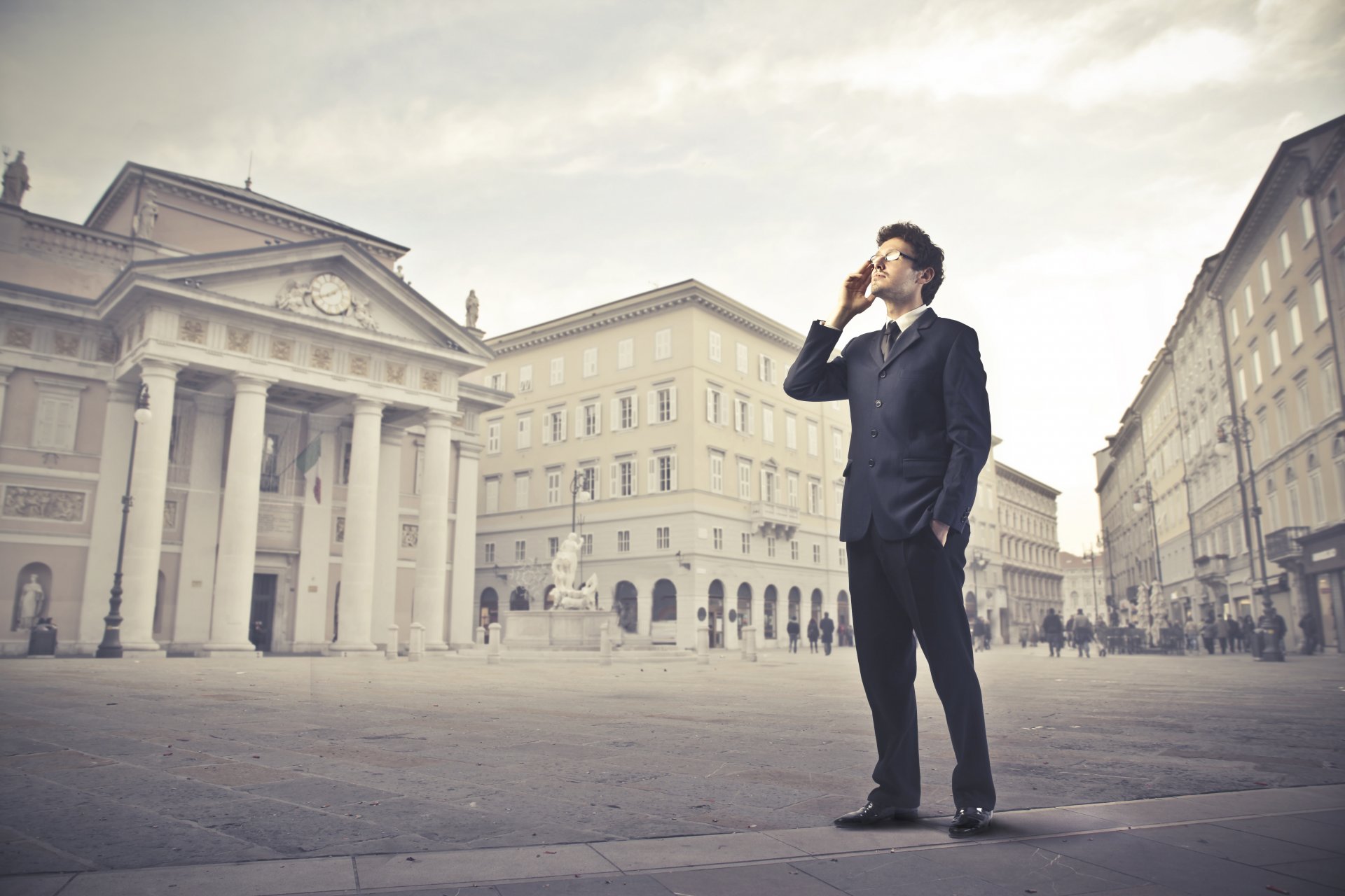 uomo occhiali vestito giacca pantaloni telefono città strada persone