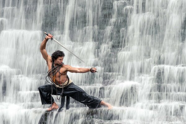 Guy sur une cascade avec un sabre montre Kung Fu