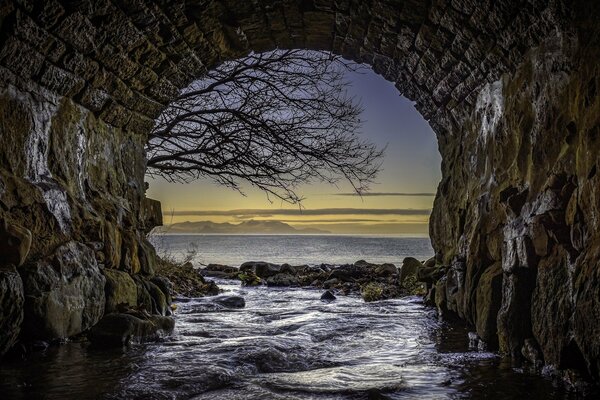 Schöner Blick auf das Wasser durch einen Tunnel in Schottland