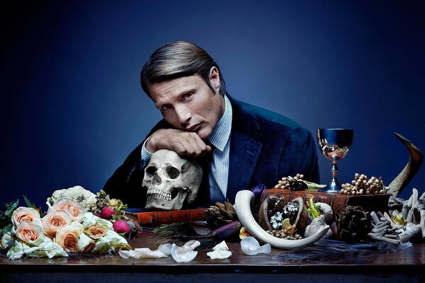 The man leans on the skull and poses