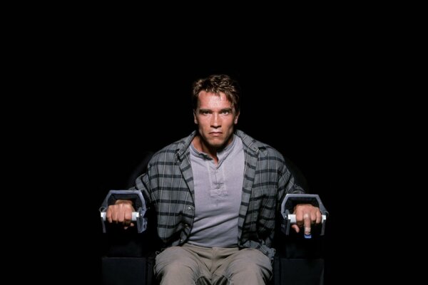 En colère Arnold Schwarzenegger enchaîné à une chaise
