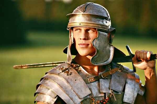 En el campo de un romano en un traje con una espada