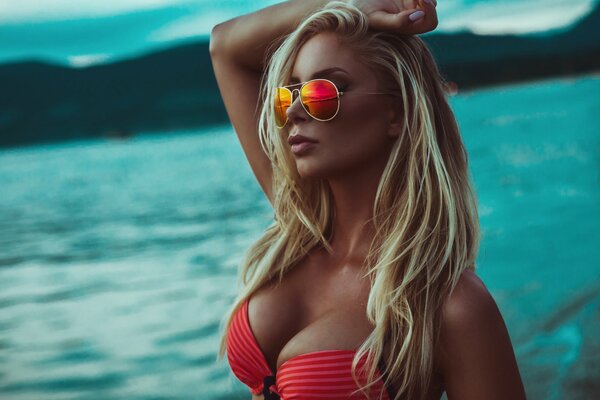 A model in aviator glasses and a red swimsuit