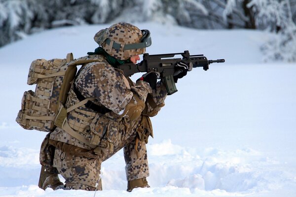 A soldier of the Latvian army shoots in the winter forest