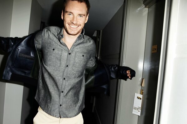 Michael fassbender goes and puts on a jacket